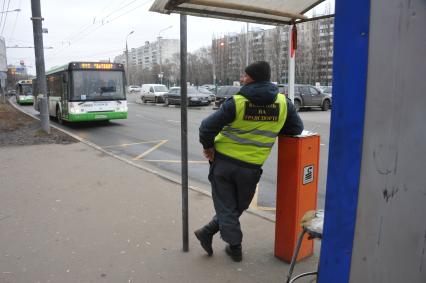 Автобус подъезжает к автобусной остановке.