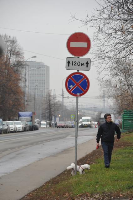 Мужчина выгуливает собаку.