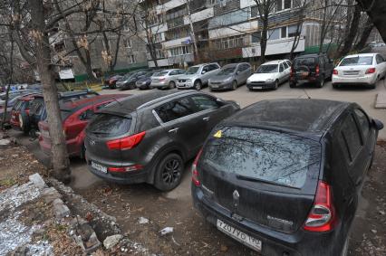 Автомобили припаркованные во дворе.