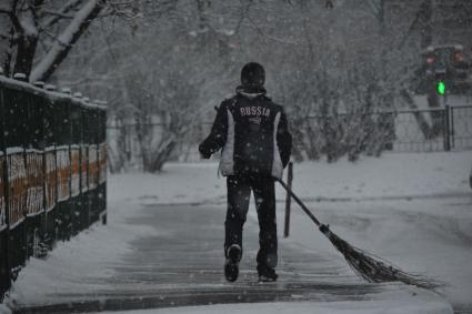 Снегопад в Москве. На снимке:  мужчина подметает тротуар от снега