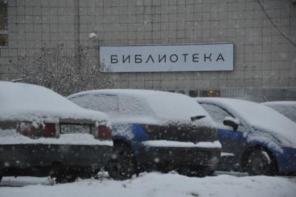 Снегопад в Москве. На снимке:  автомобили припаркованные около библиотеки.