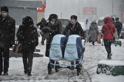 Снегопад в Москве. На снимке: женщина с коляской для двойни.