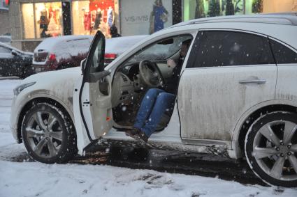 Снегопад в Москве. На снимке: мужчина сидит в автомобиле.