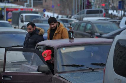 Парковка автомобилей. На снимке: бутылка с алкоголем на крыше автомобиля.