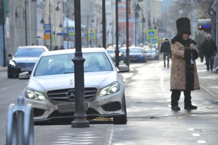 Припаркованный автомобиль около фонарного столба.