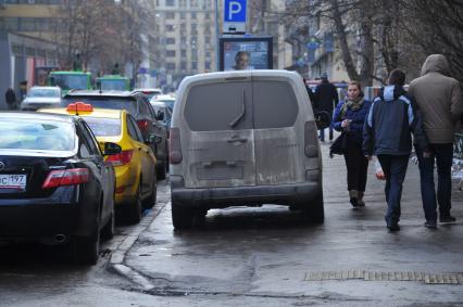 Парковка автомобилей. На снимке:  грязный автомобиль припаркованный на  тротуаре.