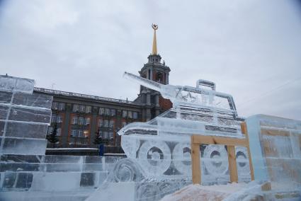 ледяная скульптура в виде танка т-34 в строящемся ледовом городке на площади 1905 года, на фоне городской администрации Екатеринбурга