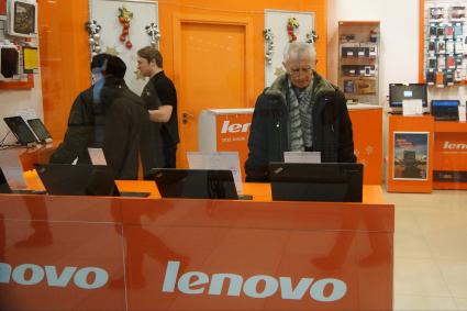 посетители смотрят ноутбуки в фирменном магазине Леново (Lenovo)