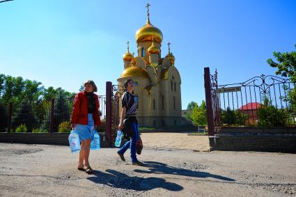 Донецк. Женщины идут с бутылками воды, которую они набрали в святом источнике в храме.