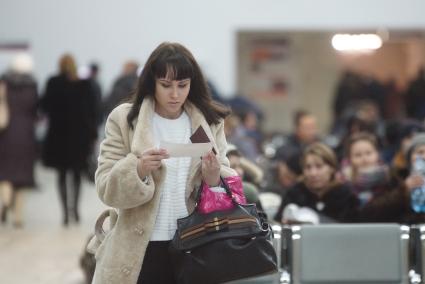 девушка с билетом на поезд в зале ожидания на  железнодорожном вокзале в Екатеринбурге