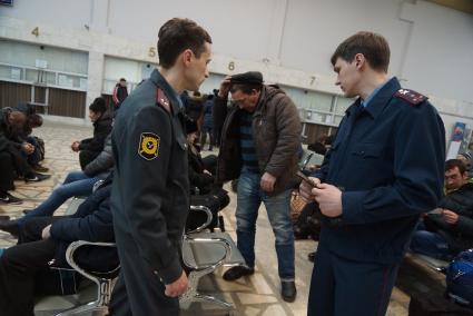 Сотрудники Полиции и УФМС проверяют документы у пассажиров в зале ожидания на  железнодорожном вокзале в Екатеринбурге