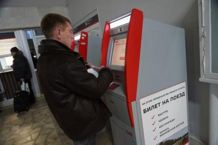 мужчина покупает билет на поезд, в терминале железнодорожного вокзала в Екатеринбурге