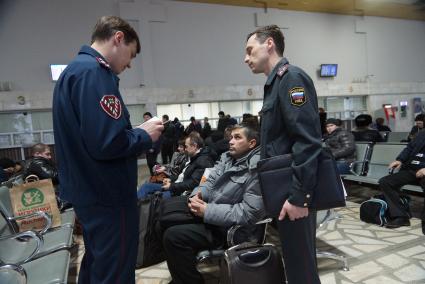 Сотрудники Полиции и УФМС проверяют документы у пассажиров в зале ожидания на  железнодорожном вокзале в Екатеринбурге