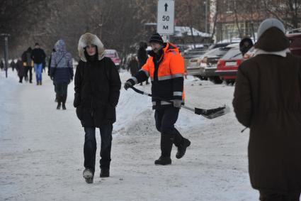 Последствия снегопада в Москве. На снимке: дворник с лопатой убирает снег.