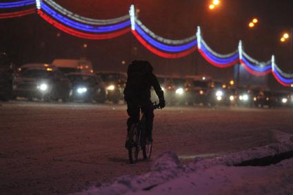 Снегопад в Москве. На снимке: велосипедист едет по дороге.