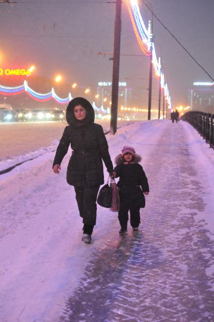 Последствия снегопада в Москве. На снимке: женщина с ребенком идут по мосту.