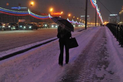 Снегопад в Москве. На снимке: женщина под зонтом идет по мосту.