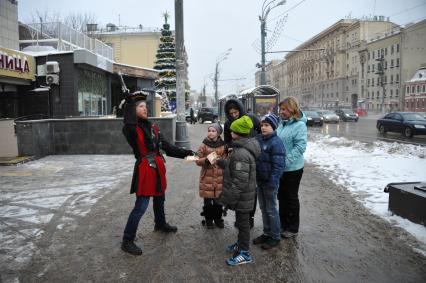 Аниматор в костюме пирата раздает детям флайерсы.