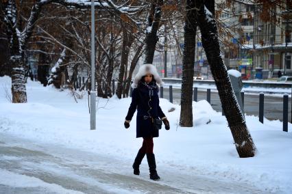Последствия снегопада. На снимке: девушка идет по улице.