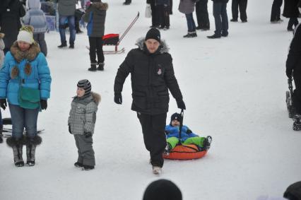 Усадьба Деда Мороза в Кузьминках. На снимке: папа везет сына на тюбе.