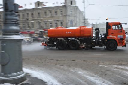 Снегопад в Москве. На снимке: дорожная машина едет по Ленинградскому проспекту мимо Белорусского вокзала.