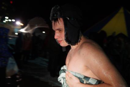 мужчина в шапке-ушанке вытирается после купания в проруби. Крещенские купания в Екатеринбурге