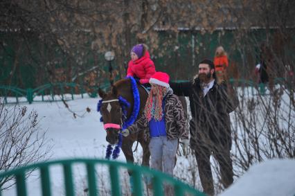 Московская усадьба Деда Мороза в Кузьминках. На снимке:  ребенок катается верхом на лошади.