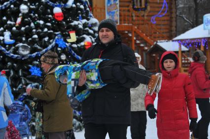 Московская усадьба Деда Мороза в Кузьминках. На снимке:  мужчина держит ребенка на руках.