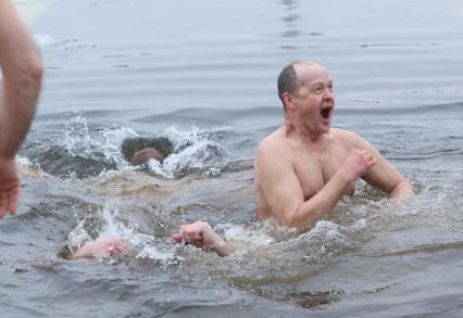 Крещенские купания в Санкт-Петербурге. На снимке: мужчина окунается в прорубь в Неве у Петропавловской крепости.