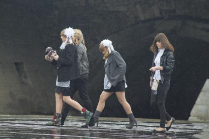 школьницы во время празднования последнего звонка идут под дождем