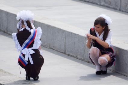 выпускницы фотографируются во время празднования последнего звонка. Набережная Исети в Екатеринбурге.