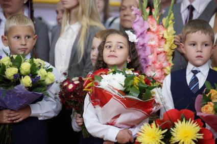 дети с букетами цветов на школьной линейке 1 сентября.