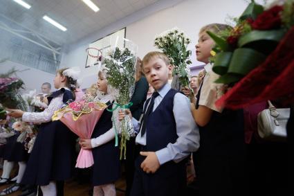 дети с букетами цветов на школьной линейке 1 сентября.