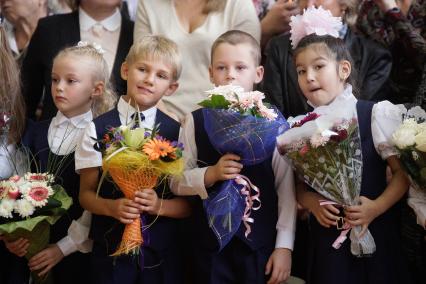 дети с букетами цветов на школьной линейке 1 сентября.