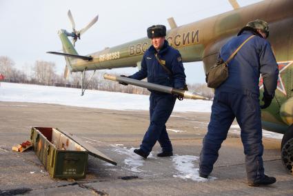 техники заряжают ракеты НУРС в пусковую установку вертолетов Ми-8 войсковой части ВВС в Каменске-Уральском, перед началом учебного, воздушного минирования