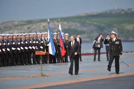 Североморск. Военно-морской парад в День ВМФ РФ. На снимке:  президент РФ Владимир Путин (в центре) и командир авианосца `Адмирал флота Советского Союза Кузнецов`, капитан 1 ранга Сергей Артамонов (справа) на палубе тяжелого авианесущего крейсера `Адмирал флота Советского Союза Кузнецов`..