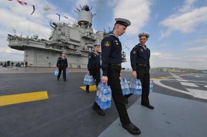 Североморск. Военно-морской парад в День ВМФ РФ. Тяжелый авианесущий крейсер `Адмирал флота Советского Союза Кузнецов`. На снимке: военнослужащие несут упаковки с минеральной водой.