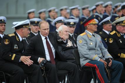 Североморск. Военно-морской парад в День ВМФ РФ. На снимке (слева направо): командир авианосца `Адмирал флота Советского Союза Кузнецов`, капитан 1 ранга Сергей Артамонов, президент РФ Владимир Путин и министр обороны РФ Сергей Шойгу.