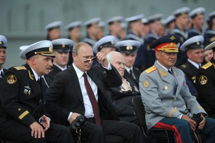 Североморск. Военно-морской парад в День ВМФ РФ. На снимке (слева направо): командир авианосца `Адмирал флота Советского Союза Кузнецов`, капитан 1 ранга Сергей Артамонов, президент РФ Владимир Путин и министр обороны РФ Сергей Шойгу.