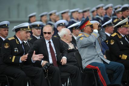 Североморск. Военно-морской парад в День ВМФ РФ. На снимке (слева направо): командир авианосца `Адмирал флота Советского Союза Кузнецов`, капитан 1 ранга Сергей Артамонов, президент РФ Владимир Путин и министр обороны РФ Сергей Шойгу.