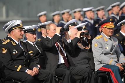 Североморск. Военно-морской парад в День ВМФ РФ. На снимке (слева направо): командир авианосца `Адмирал флота Советского Союза Кузнецов`, капитан 1 ранга Сергей Артамонов, президент РФ Владимир Путин и министр обороны РФ Сергей Шойгу.