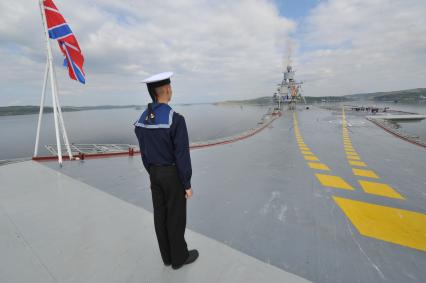 Североморск. Военно-морской парад в День ВМФ РФ. Тяжелый авианесущий крейсер `Адмирал флота Советского Союза Кузнецов`. На снимке: военнослужащий стоит на палубе крейсера.