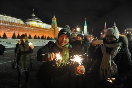 Празднование Старого Нового года в Москве. На снимке: люди с бенгальскими огнями на Красной площади.