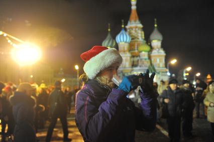 Празднование Старого Нового года в Москве. На снимке: девушка держит во рту пластиковый стакан с шампанским  на Красной площади.