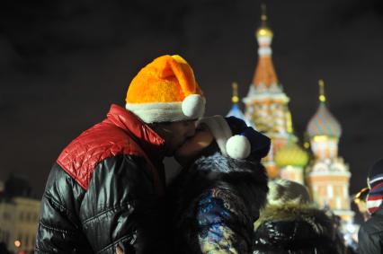 Празднование Старого Нового года в Москве. На снимке: целующиеся влюбленные в шапках Деда Мороза на Красной площади.