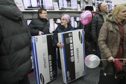 Барнаул. Открытие нового магазина бытовой техники и электроники Media Markt. На снимке: покупатели стоят в очереди в кассу и держат телевизоры с поддержкой Smart TV.