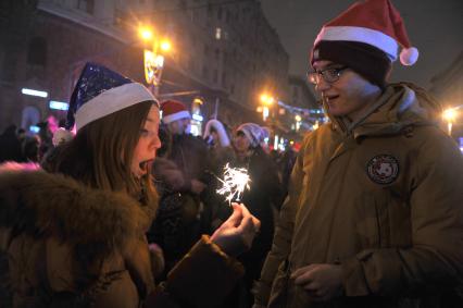 Празднование Нового года на Тверской улице в Москве. На снимке: девушка с бенгальским огнем.