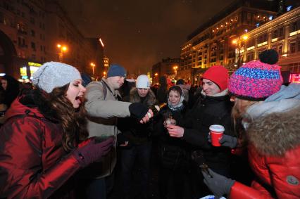 Празднование Нового года на Тверской улице в Москве. На снимке: молодые люди разливают шампанское в бокалы.