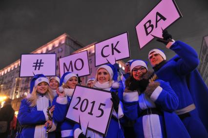 Празднование Нового года на Тверской улице в Москве. На снимке: молодые люди с табличками `Москва 2015`.