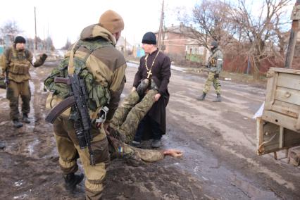 п.Красный Партизан перешел под контроль ополченцев ДНР. На снимке: ополченцы помогают отцу Дмитрию Поворотному грузить в ГАЗель трупы убитых украинских солдат.